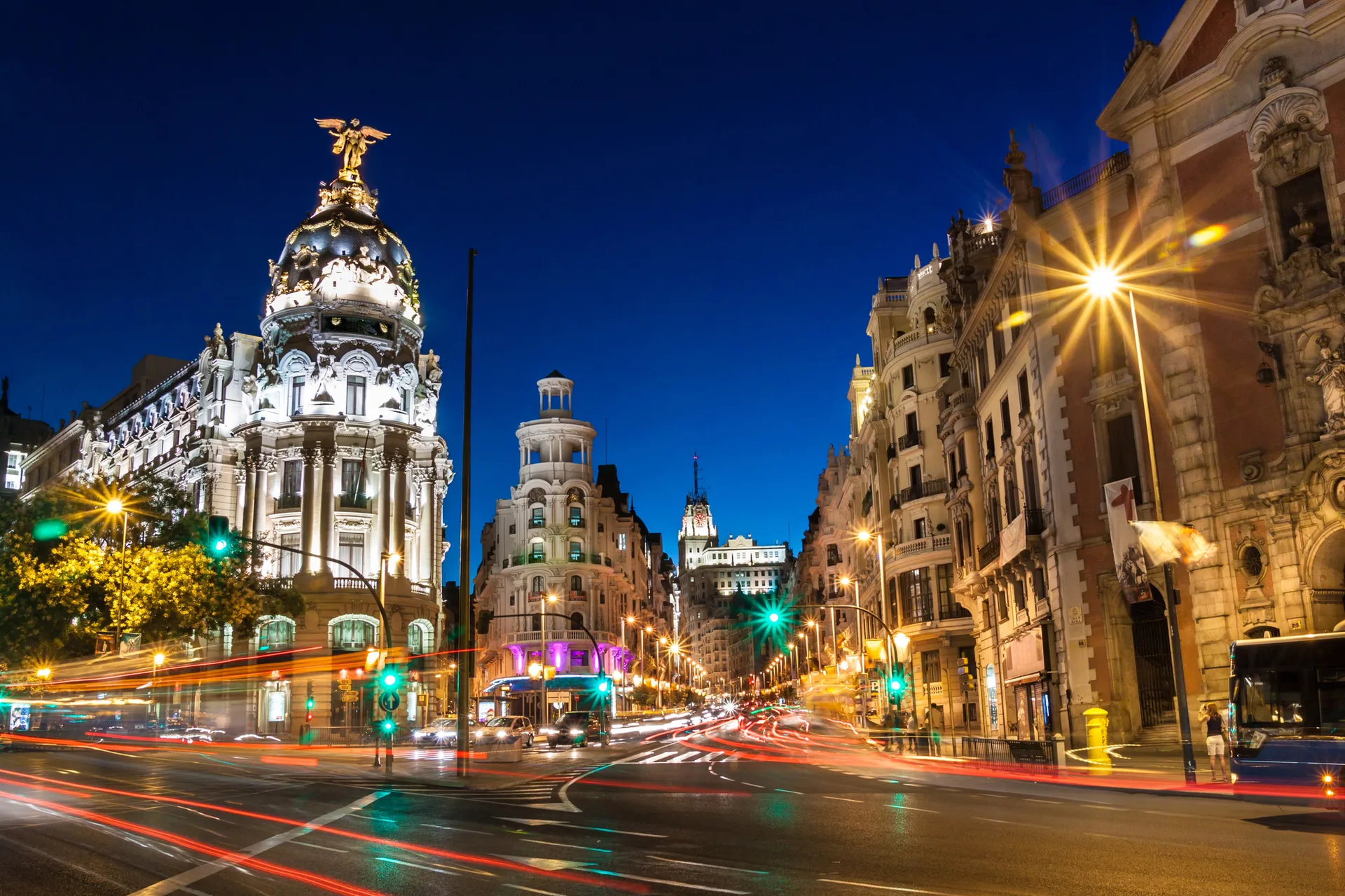 Gran Vía in Madrid, Spanien – nächtliche Stadtansicht mit beleuchtetem Edificio Metrópolis und Lichtspuren des Verkehrs
