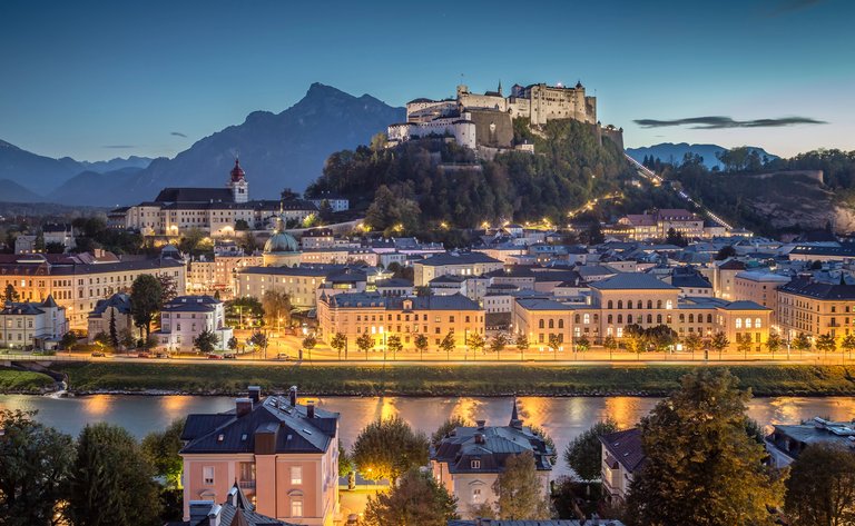 Salzburg bei Dämmerung – Festung Hohensalzburg beleuchtet über der Altstadt an der Salzach