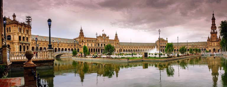 Plaza de España in Sevilla, Spanien – Halbkreisbau mit Wasserkanal und dramatischem Abendhimmel
